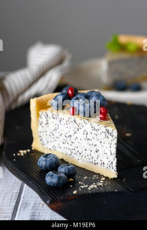 Stück Kuchen mit Mohn und Heidelbeeren. Detailansicht, selektive konzentrieren. Getonten Bild Stockfoto