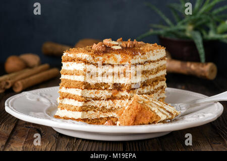 Honig Kuchen mit Mandeln auf weiße Platte. Russische Kuchen Medovik Stockfoto