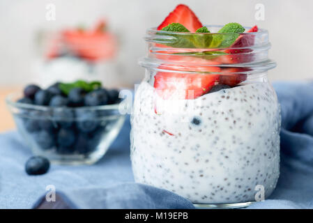 Chia Pudding in Glas mit Erdbeeren, Heidelbeeren und Minze. Detailansicht Stockfoto