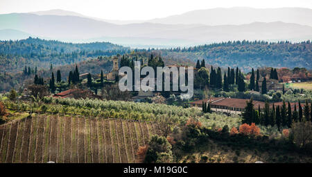 Toskanische Landschaft und Land straße mit Zypresse, Bäumen und alten Gebäuden. Region Toskana in Italien. Stockfoto