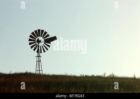 Silhouette der Windmühle im Fahrerlager, Queensland, Australien. Windmühlen sind allgemein für das Pumpen von Wasser aus den Bohrungen oder Dämme, die für die Tierhaltung verwendeten. Stockfoto