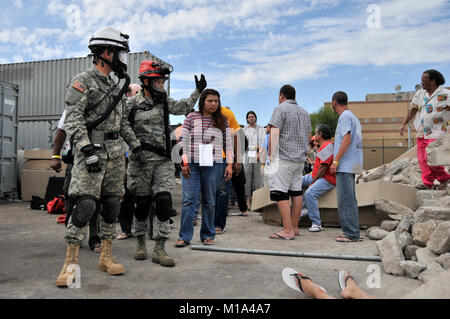 111104-Z-XQ 016-033 Tech Sgt. Eliza Villa von Fresno, Kalifornien, ein Medic mit Die 144 Fighter Wing, California Air National Guard (roter Helm) und Pfc. Giovanny Guzman von Walnut Creek, Kalifornien, eine Bekämpfung der Ingenieur mit dem 235Th Engineer Company, 579 Engineer Battalion, 49th Military Police Brigade, Oklahoma Army National Guard, führen die Opfer, die in der Lage sind, von der simulierten Katastrophe zu einem Dekontamination Bereich während der 2011 Arizona wachsam Guard Übung Nov. 4, 2011 in Phoenix zu gehen. Mehr als 500 Kalifornien Nationalgarde Soldaten und Piloten in der landesweiten Übung, die in Fördergebieten Stockfoto