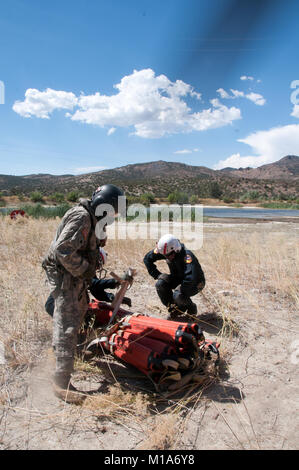 Sgt. Chris Boni der 1-140 th Aviation Battalion (Air Assault), links, und Bob Innes, Brand Manager für cal Feuer, sichern Sie die Bambi bucket vor Kämpfen der RIM Brand- und Kieferknochen komplizierte Feuer in Tehachapi, Calif., Aug 14. (Air National Guard Foto/Master Sgt. Julie Avey) Stockfoto