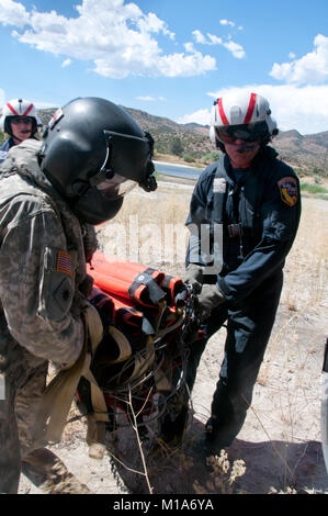 Sgt. Chris Boni der 1-140 th Aviation Battalion (Air Assault), links, und Bob Innes, Brand Manager für cal Feuer, sichern Sie die Bambi bucket vor Kämpfen der RIM Brand- und Kieferknochen komplizierte Feuer in Tehachapi, Calif., Aug 14. (Air National Guard Foto/Master Sgt. Julie Avey) Stockfoto