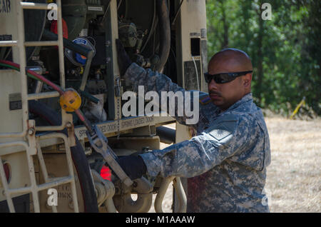 Oklahoma Army National Guard SPC. Spc. Ernan Ramirez, ein Los Angeles native und Bewohner vom 1.BATAILLON, 140 Aviation Regiment, Kraftstoffe, eine UH-72A Lakota Hubschrauber Landing Zone in der Lodge Feuer in der Nähe von Laytonville, Calif., 10.08.2014. Wie fuelers Pollard sind unerlässlich, um die Hubschrauber fliegen. Stockfoto