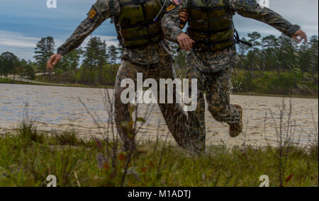 Us-Armee Sgt. 1. Klasse Jonathan Knea (links) hilft sein Mannschaftskamerad, Staff Sgt. Lukas Katz (rechts), der die Nationalgarde zugewiesen, in Richtung der nächsten Veranstaltung nach Abschluss der Teich schwimmen Veranstaltung während der besten Ranger Wettbewerb auf Ft. Benning, Ga, 15. April 2016. Die 33. jährliche besten Ranger Wettbewerb 2016 ist eine dreitägige Veranstaltung, bestehend aus Herausforderungen Wettbewerber des körperlichen, geistigen und technischen Fähigkeiten zu Ehren von Generalleutnant David E. Grange, Jr. (U.S. Air Force Foto von älteren Flieger Colville McFee/Freigegeben) Stockfoto