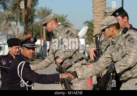 100312-A-001 -0691 S Soldaten der 49th Military Police Brigade (SPC. Wesley Adams, Links, SPC. Rommel Vazquez, rechts, und Staff Sgt. Keith George, versteckte) Grüße irakische Polizisten. Die Soldaten sind Mitglieder der 49 th Personal Security Detail, die eine wichtige Rolle für die Kalifornien Brigade während des Nationalen irakischen Wahlen März 7 gespielt. (Army National Guard Foto/SPC. Eddie Siguenza) Stockfoto