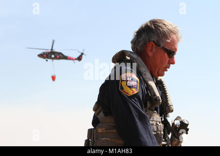 Kapitän Bob Imnes, militärische Hubschrauber Manager der Kalifornien Abteilung der Forstwirtschaft und des Feuerschutzes (CAL FEUER), Vorbereitungen seinen Flug Anzug als CalGuard UH-60 Black Hawk kehrt aus dem Garza Brand Juli 13 am Coalinga Municipal Airport, Fresno County, Kalifornien kämpft. CalGuard Imnes und seine Crew lief zwei Missionen, die jeweils etwa zwei Stunden, Spritzwasser auf dem Kings County Blaze. (Army National Guard Foto/Staff Sgt. Eddie Siguenza) Stockfoto