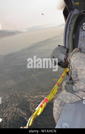 Oklahoma Army National Guard Chief Warrant Officer zwei Scott Smith und Bryan Bartucci vom 1-140 th Aviation Battalion (Air Assault), Los Alamitos, fliegen die UH-60 Black Hawk, 12.08.29, 2013, von der Mather Flugbetrieb der dip-Website im Cherry Lake Dam gerade westlich von Yosemite National Park zu 16 verschiedenen Eimer fallen Seiten fünf Minuten entfernt. Die Piloten bewegen sich in der Cal Brand Manager geleitet, Feuer Kapitän John Zuniga, die Flecken US Forest Service Feuerwehrleute auf dem Boden und Signale SPC. Michael Beatty, der Mannschaft Leiter der Eimer Wasser in der Nähe von Bereichen, in denen die zu fallen Stockfoto