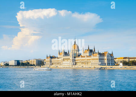 Das Parlamentsgebäude in Budapest, Ungarn auf einem hellen, sonnigen Tag mit Passagierschiff. Dieses Bild ist getönt. Stockfoto