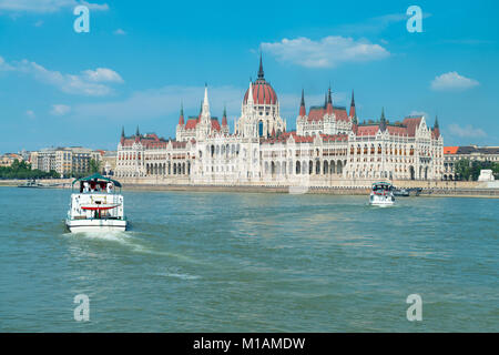 Parlamentsgebäude in Budapest, Ungarn an einem sonnigen Tag mit zwei Fahrgastschiffe Stockfoto