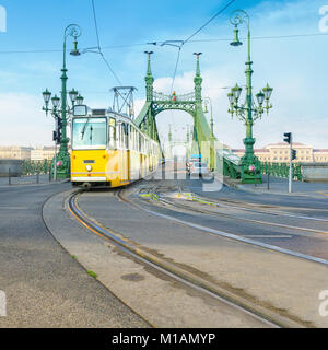 Historische Straßenbahn über die Brücke in Budapest, Ungarn, an einem hellen Tag Stockfoto