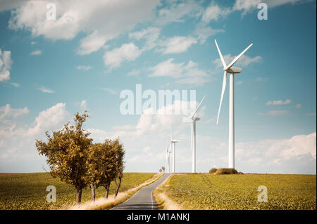 Moderne Windmühlen erzeugen elektrische Energie entlang Land straße, text Raum Stockfoto