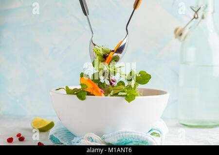 Rühren ein helles Kaki Salat. Gesunde vegetarische Essen Konzept. Stockfoto