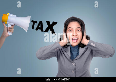 Asian Business Frau ihre Ohren von Megafon mit Steuer Text gegen den hellen Hintergrund Stockfoto