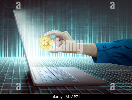Frauen Hand mit Laptop und goldene Bitcoin über digitale Hintergrund Stockfoto
