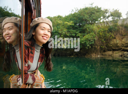 Mädchen genießt die Fahrt auf einem hölzernen Touristenboot Stockfoto