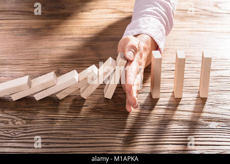 Close-up ist eine weibliche Hand Anhalten der Domino auf hölzernen Schreibtisch Stockfoto