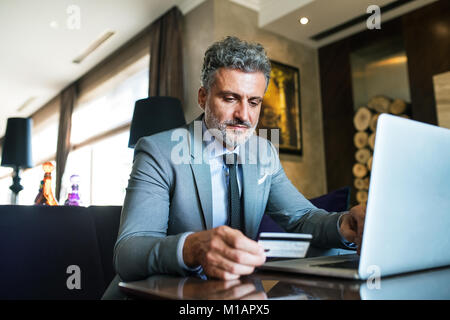 Reifen Geschäftsmann mit Laptop in einem Hotel Lounge. Stockfoto