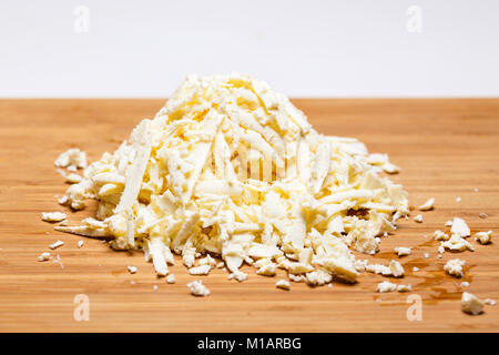 Geriebenen Mozzarella-Käse auf ein Schneidebrett mit einer Reibe Stockfoto