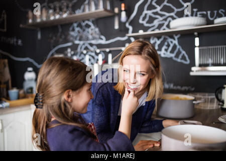 Ein kleines Mädchen mit ihrer Mutter kochen zu Hause. Stockfoto