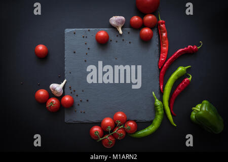 Blick von oben auf die frische reife Tomaten, Paprika und Knoblauch mit Blank Slate board Stockfoto