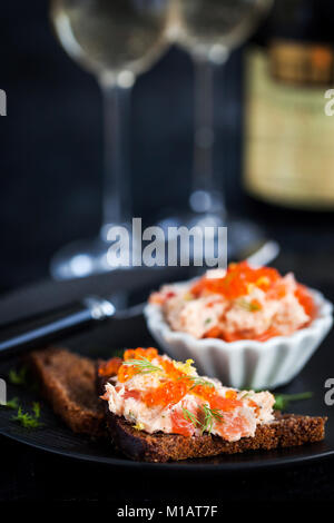 Lachs, Pastete (Rillettes) mit rotem Kaviar mit geschnittenem Brot serviert. Stockfoto