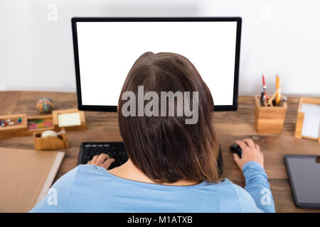 Ansicht der Rückseite eine Frau sitzen Vor Der Desktop zu Hause Stockfoto
