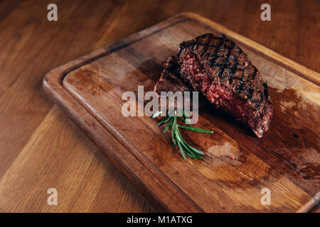 Medium gegrilltes Steak auf Holzbrett Stockfoto