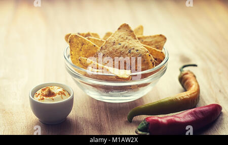 Mais Chips in der jar. Traditionelle Snack für Bier mexikanische Nachos. Nachos mit Gewürzen und Pfeffer auf Holztisch. Stockfoto