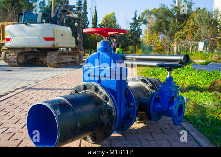 Nahaufnahme der Installation von Wasser- Rohr Ventil in einen Graben mit Wasser Stockfoto