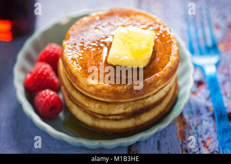 American Pancakes mit Butter und Ahornsirup und Himbeeren Stockfoto