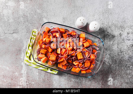 Süsse Kartoffeln auf ein Backblech gebacken mit Zwiebel, bereit für den Dienst auf einem Tisch aus Stein Stockfoto