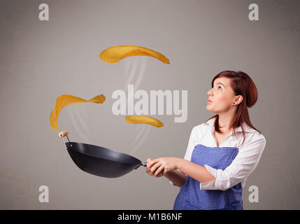 Schöne junge Frau Pfannkuchen machen Stockfoto