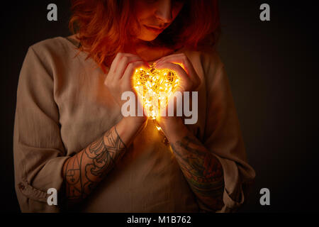 Frau mit Lichter in der Form eines Herzens Stockfoto