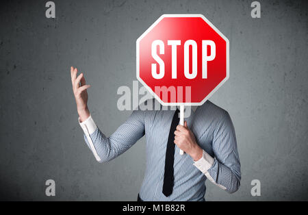 Unternehmer stehen und halten ein Stop Schild vor dem Kopf Stockfoto