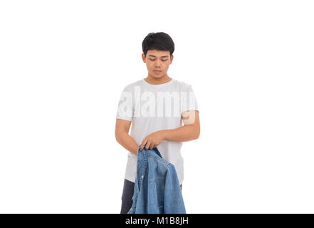 Eine asiatische Junge mit schwarzen Haaren setzt an im Studio mit weißem Hemd und Jeans Jacke. Stockfoto