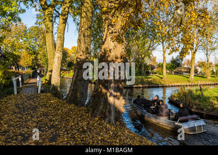 Giethoorn, Niederlande - 31. Oktober 2016: elektrische Boot im Herbst in den Kanälen der kleinen, malerischen Städtchen Giethoorn, Overijssel, Netherl Stockfoto