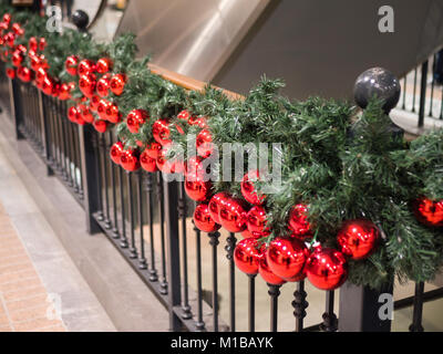 Roten Weihnachtskugeln schmücken das Innere einer Shopping Mall Stockfoto