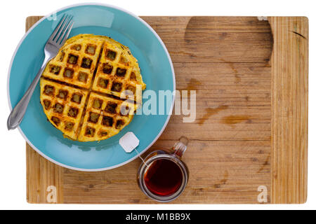 Golden knusprig gebratener Hash Brown mit honey comb waffle Muster auf einem blauen Schild mit einem Teebeutel in eine Tasse mit heißem Wasser neben im vi. Stockfoto