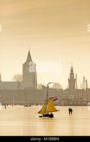 Die Niederlande, Monnickendam, Skyline von Dorf. eis Segelboot auf dem zugefrorenen See namens Gouwzee. Winter. Stockfoto