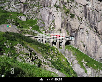 Red Express Zug am malerischen steinigen St. Gotthard Bahn Brücke und Tunnel, Schweizer Alpen, Schweiz Stockfoto