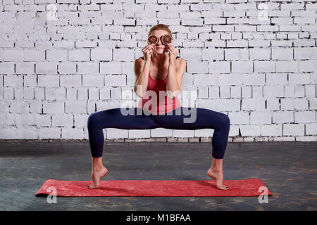 Junge attraktive lächelnde Frau mit Yoga. Sportliche hübsche Frau liebt Sport. Stockfoto