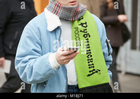 Mailand - Januar 15: Mann mit grünem Schal und Blue Jeans Jacke an Smartphone suchen vor Giorgio Armani Fashion Show, Mailand Fashion Week Straße sty Stockfoto