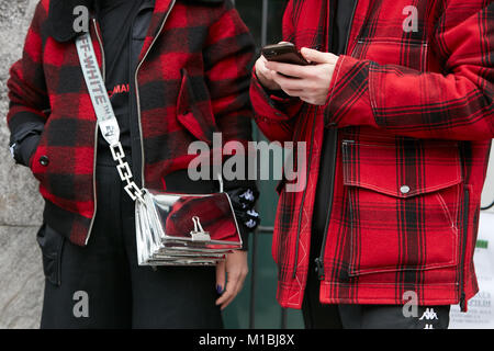 Mailand - Januar 15: Frau und Mann mit Rot und Schwarz karierten jacke und Off White Silver Beutel vor Giorgio Armani Fashion Show, Mailand Fashion Week Stockfoto