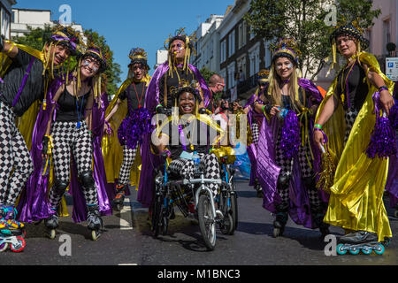 Gruppe von Skatern in Gelb Gold und Purpur Kostüme im Karneval in Notting Hill, London, UK Stockfoto