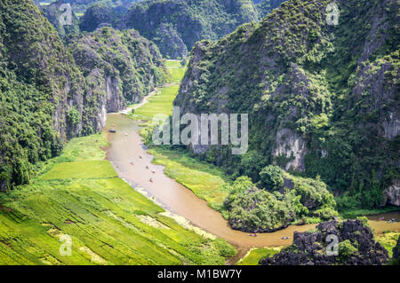 Luftaufnahme des Flusses zwischen Reisfeldern und Kalkstein Berge, Vietnamesisch malerische Landschaft bei Ninh Binh, Vietnam Stockfoto