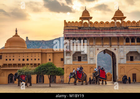 Touristen genießen Elefantenritt an Amer Fort Jaipur Rajasthan bei Sonnenaufgang. Amber Fort ist ein UNESCO Weltkulturerbe Stockfoto