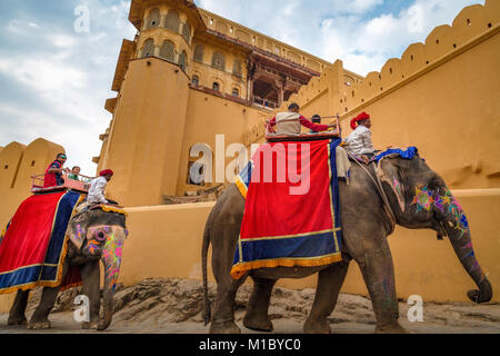 Touristen genießen dekorierte Indische Elefanten bei Amer Fort (Fort Amber) Jaipur, Rajasthan Indien fahren. Stockfoto