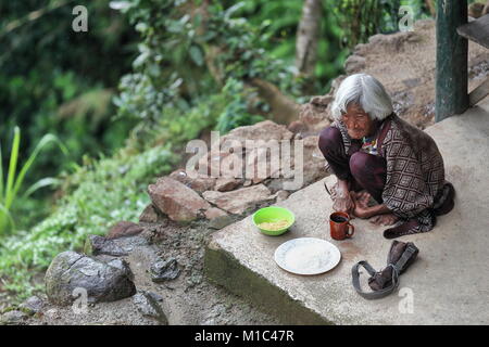 Batad, Philippines-October 7, 2016: Ifugao alte Frau isst Reis und Nudeln mit einer Tasse Kaffee in der außerhalb von Ihrem Haus. Banaue-Rice Terrassen der Stockfoto